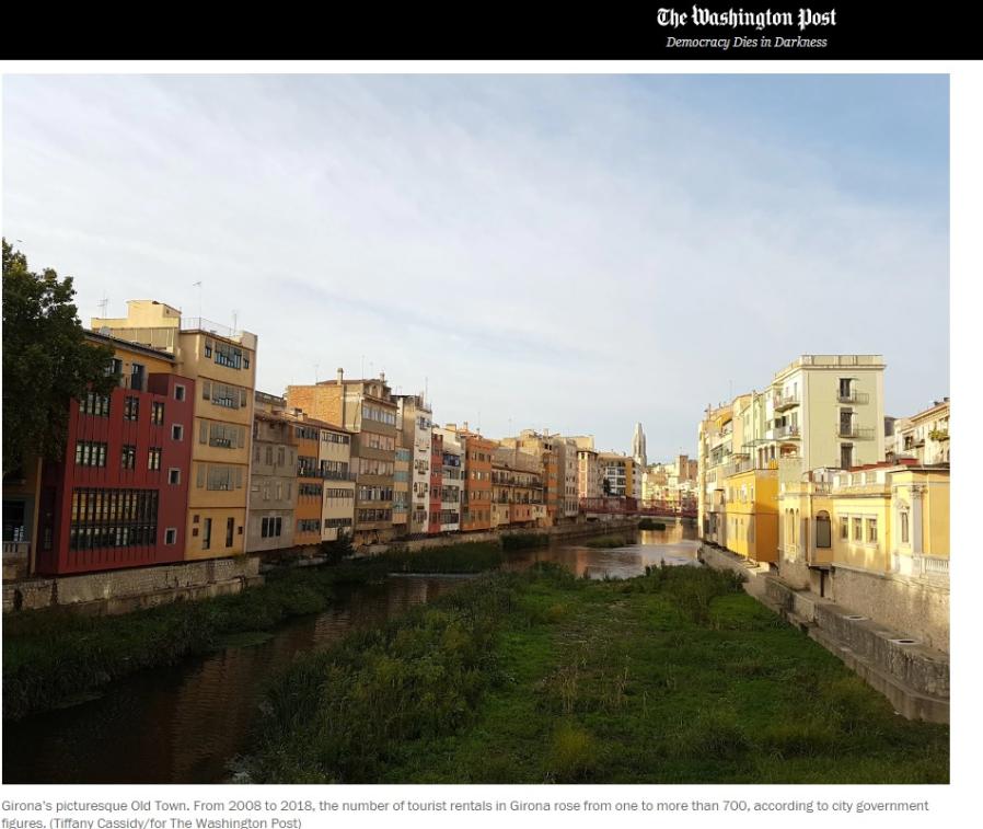 Colourful buildings stand on either side of a river at sunset. The image by Tiffany Cassidy and is in the Washington Post in a story about housing. 